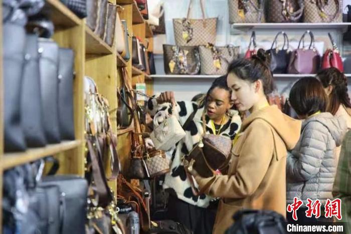 女士選購(gòu)包包?！∨砣A 攝